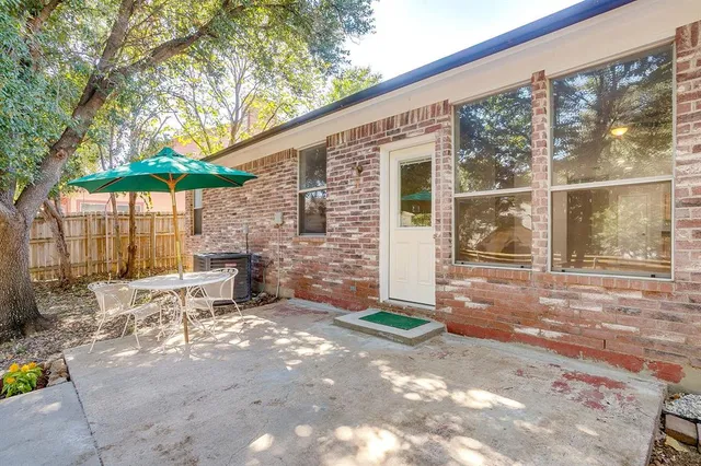 a view of a patio with table and chairs under an umbrella