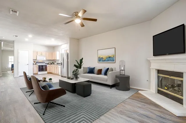 a living room with furniture a flat screen tv and a fireplace