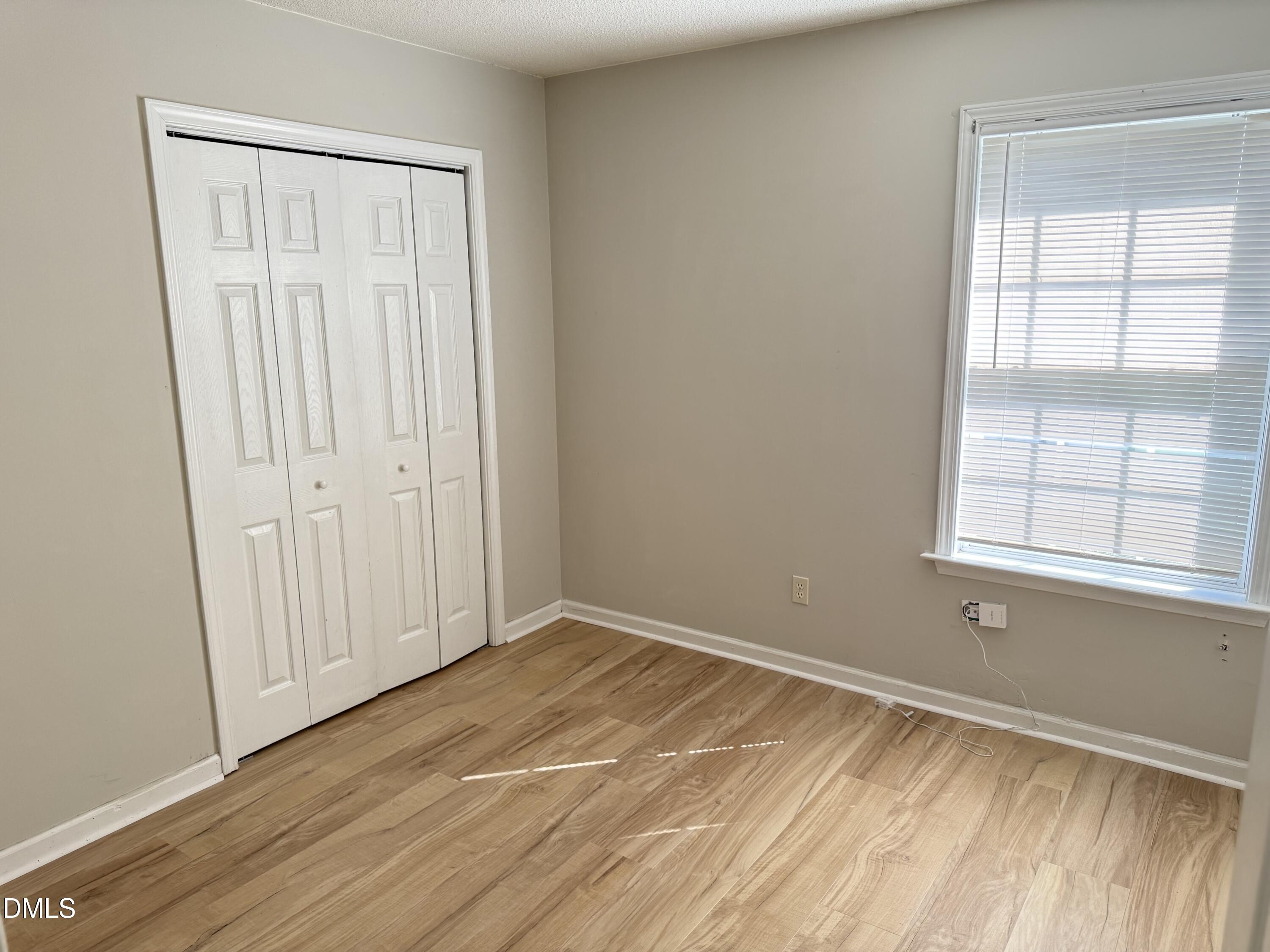 4832 Silverdene Street Raleigh, NC 27616 - Photo 13 of 15 an empty room with wooden floor and windows