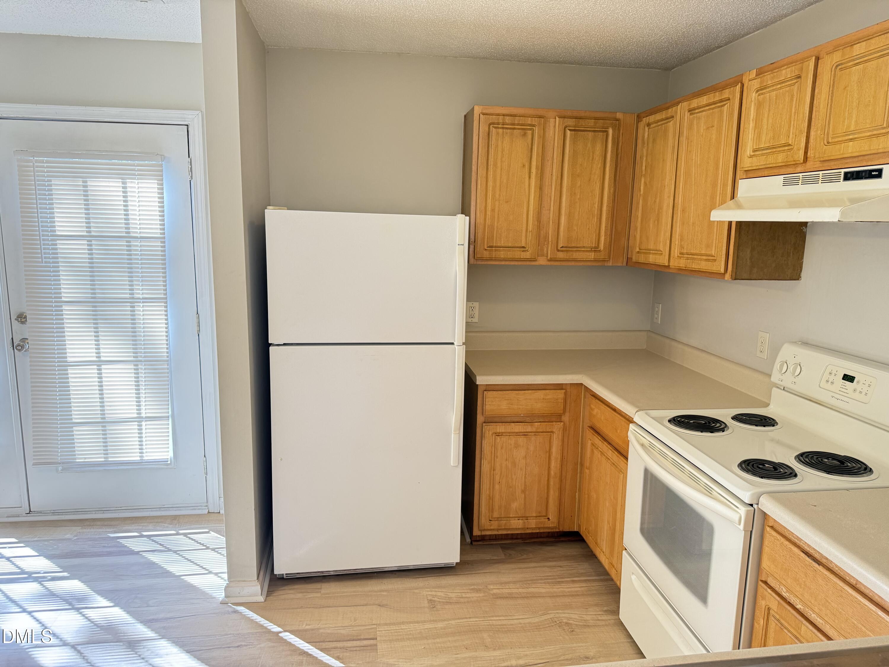 4832 Silverdene Street Raleigh, NC 27616 - Photo 8 of 15 a kitchen with a refrigerator a stove top oven and cabinets