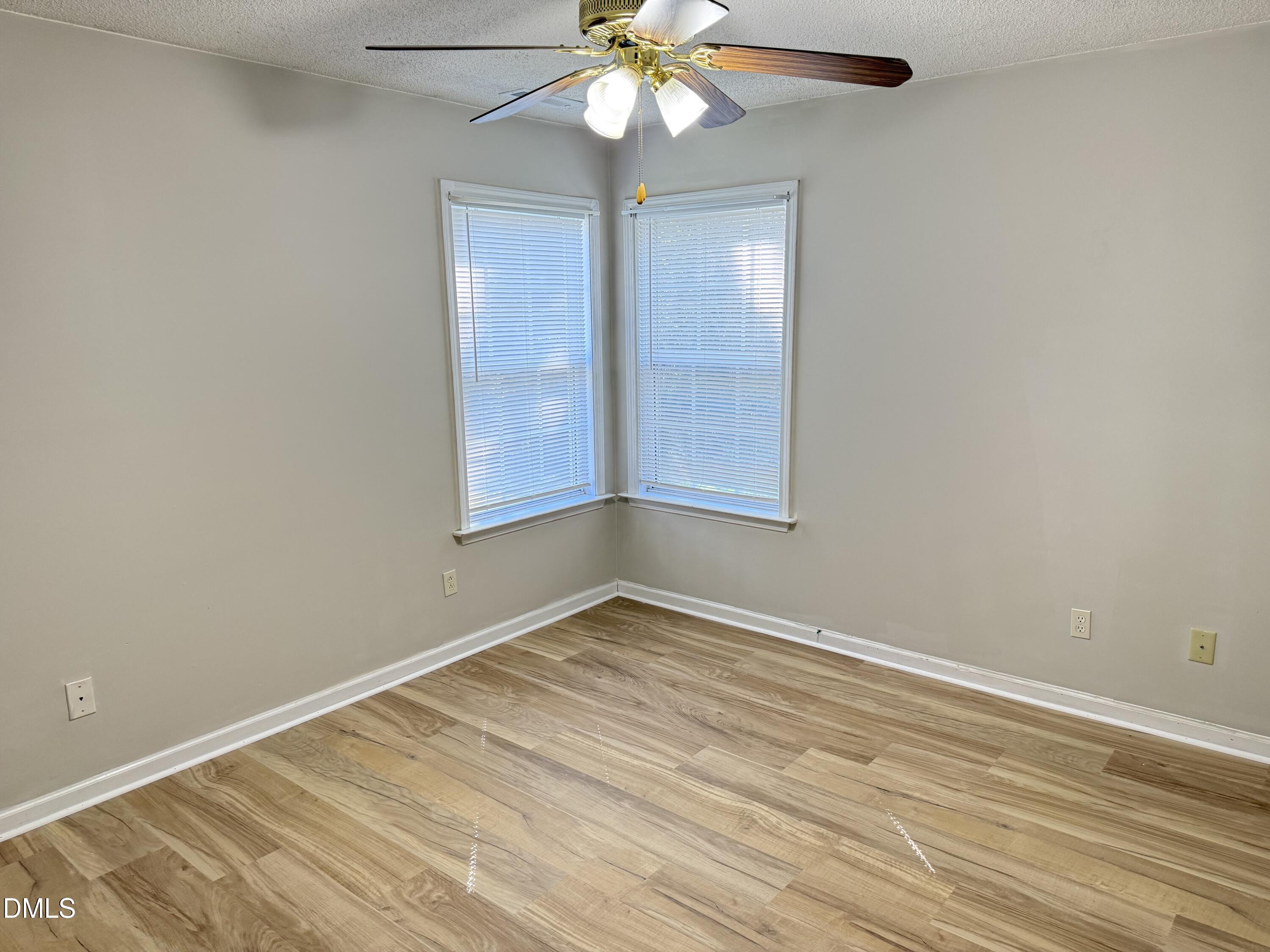 4832 Silverdene Street Raleigh, NC 27616 - Photo 9 of 15 an empty room with a chandelier fan and windows