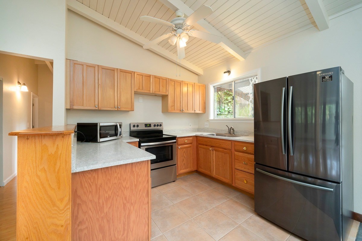 14-3508 Waimea Road Pahoa, HI 96778 - Photo 7 of 21 a kitchen with stainless steel appliances granite countertop a refrigerator a stove a sink dishwasher and a refrigerator