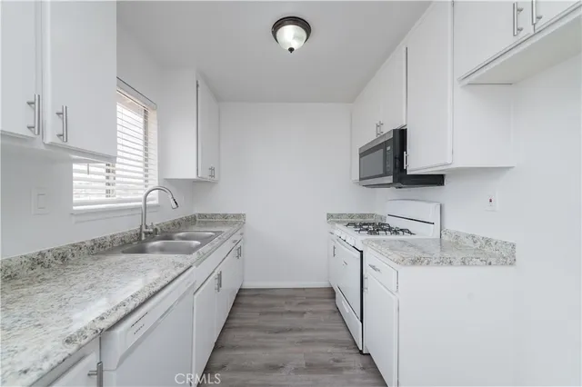 a kitchen with stainless steel appliances granite countertop a stove microwave and sink