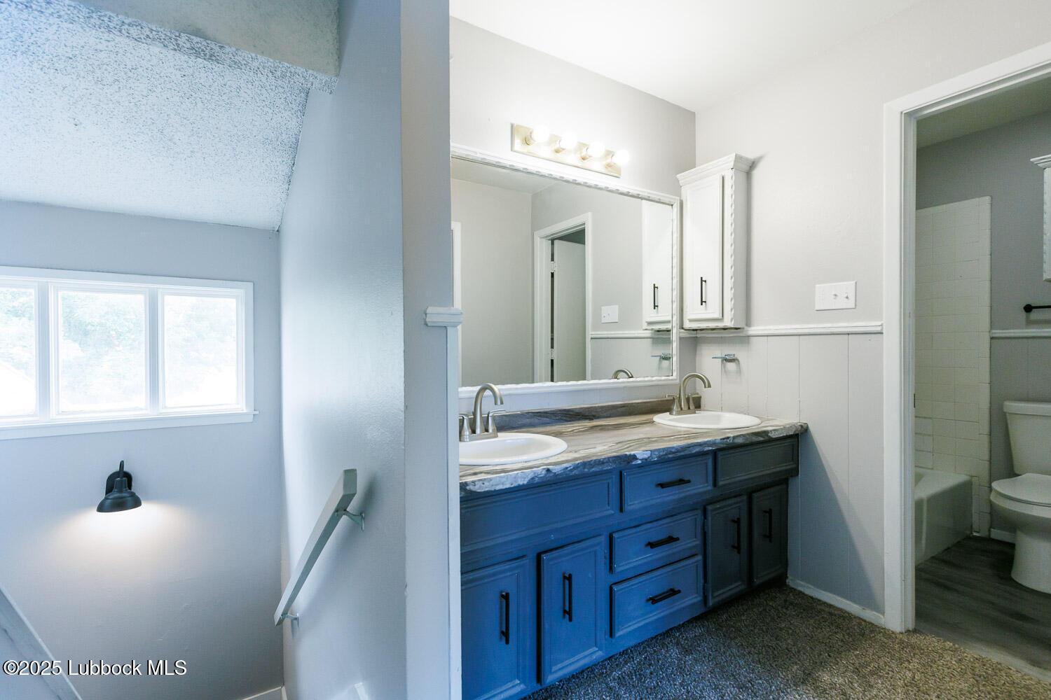 4314 52nd Street, Unit A Lubbock, TX 79413 - Photo 20 of 54 a bathroom with a granite countertop sink a toilet a mirror and a window