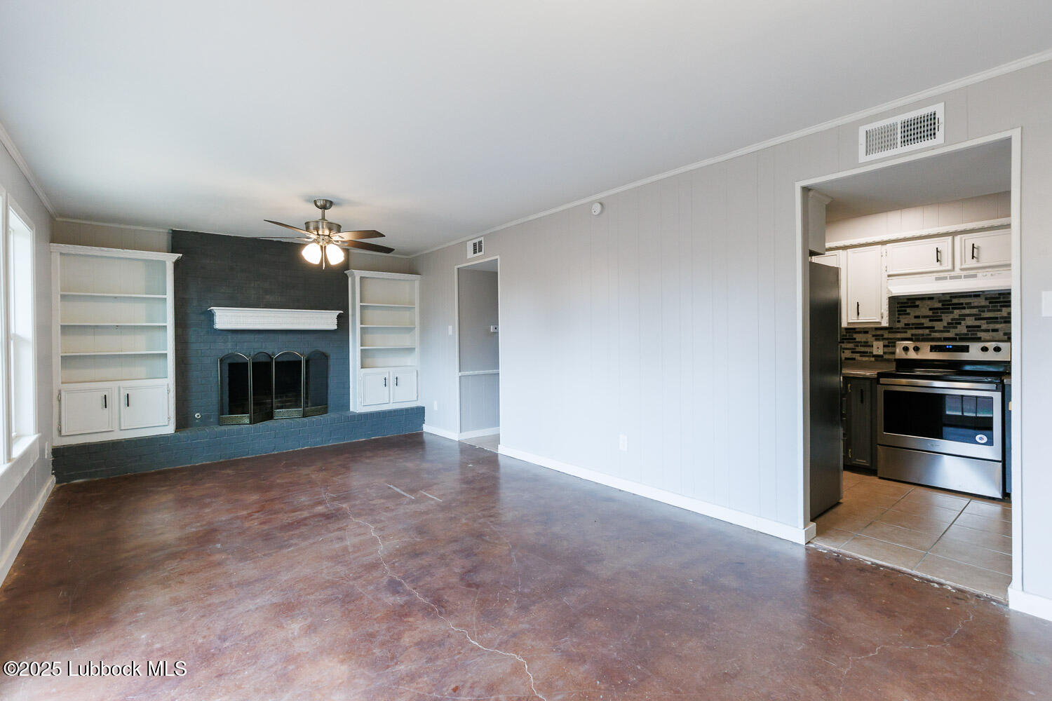 4314 52nd Street, Unit A Lubbock, TX 79413 - Photo 33 of 54 a view of an empty room with a fireplace and a window