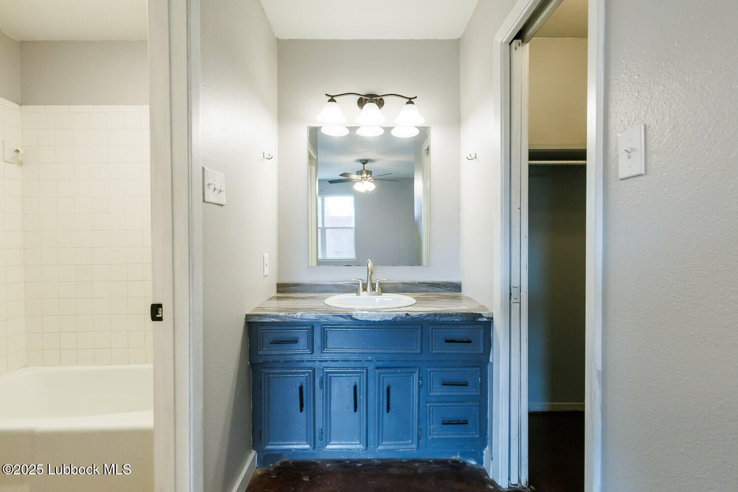 4314 52nd Street, Unit A Lubbock, TX 79413 - Photo 49 of 54 a bathroom with a granite countertop sink and a mirror
