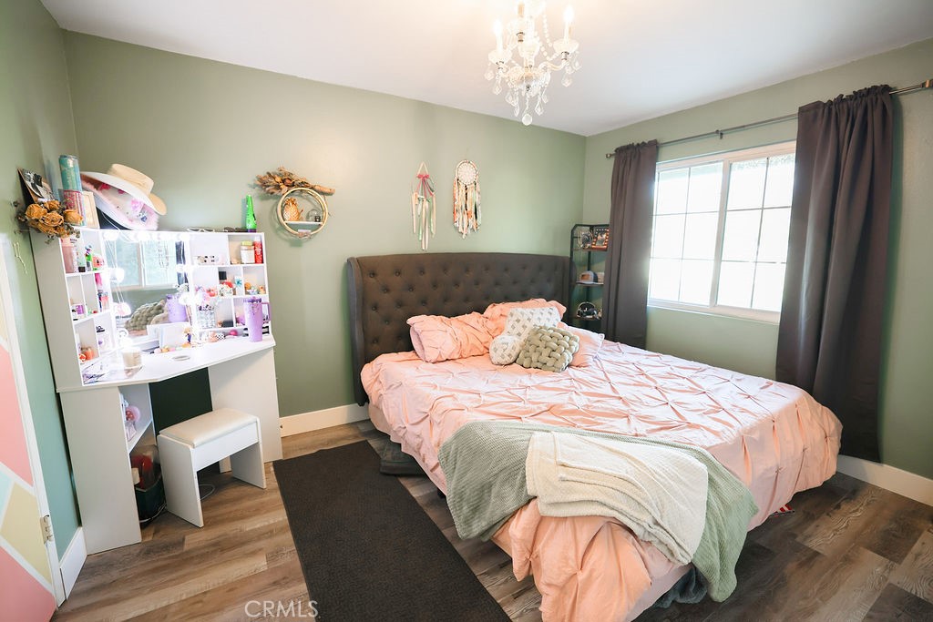 1156 3rd Street Calimesa, CA 92320 - Photo 18 of 34 a bedroom with a bed and wooden floor