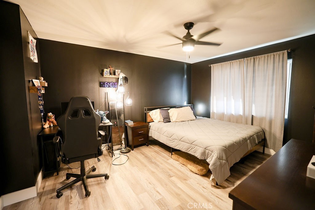 1156 3rd Street Calimesa, CA 92320 - Photo 23 of 34 a spacious bedroom with a bed a chandelier and a window