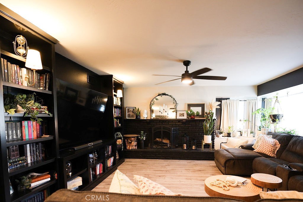 1156 3rd Street Calimesa, CA 92320 - Photo 9 of 34 a living room with furniture a bookshelf and a fireplace
