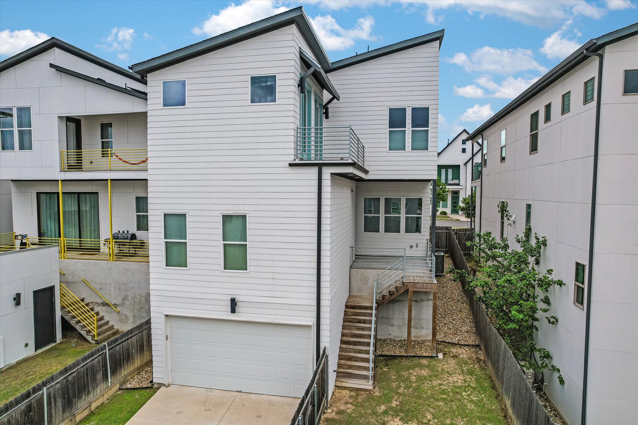 6136 Florencia Lane Austin, TX 78724 - Photo 28 of 40 Back of house with a garage, driveway, and a balcony