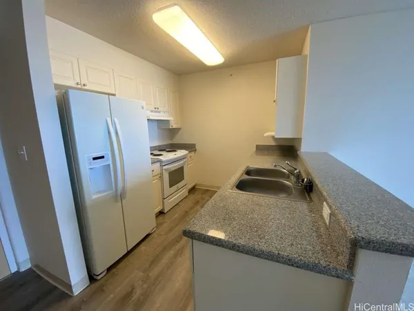 a kitchen with stainless steel appliances granite countertop a refrigerator a stove and a sink