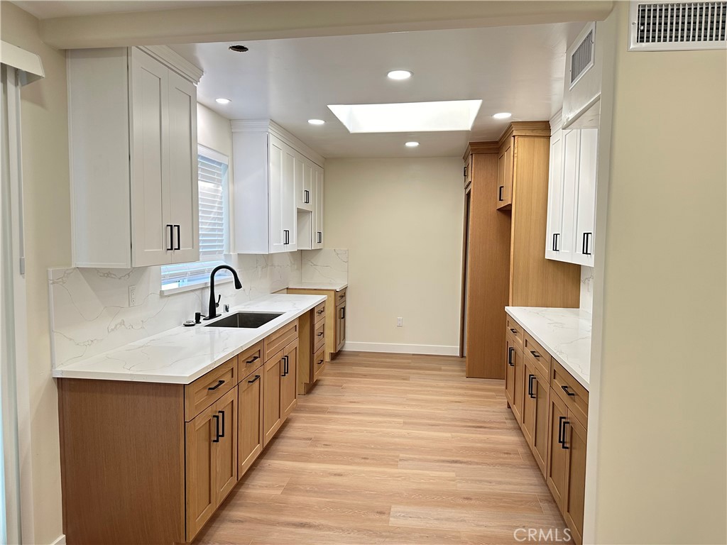 a kitchen with a sink and a wooden floor