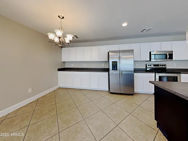 a kitchen with stainless steel appliances granite countertop a refrigerator and a stove top oven