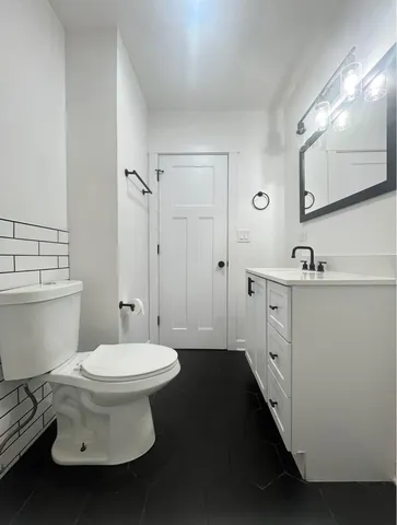 a bathroom with a sink toilet and mirror