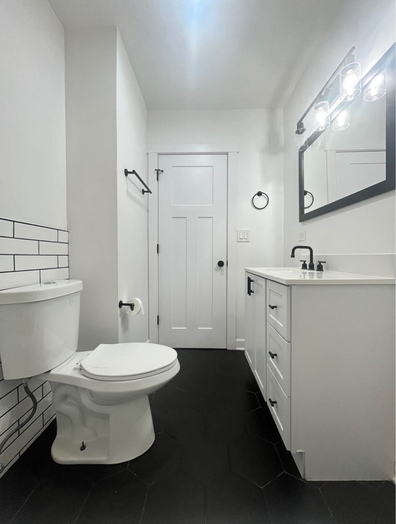 5212 South Lorel Avenue Chicago, IL 60638 - Photo 10 of 17 a bathroom with a sink toilet and mirror