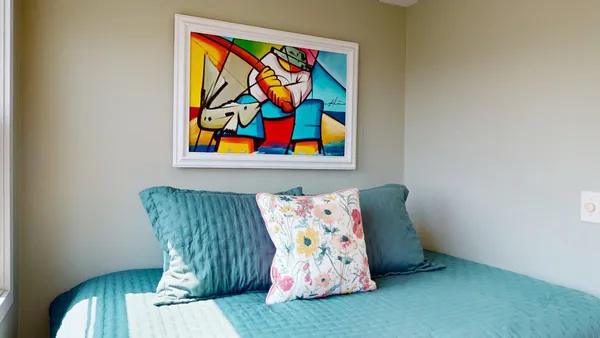 a bedroom with a bed and a large window with balcony view