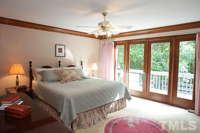 12332 Galway Drive Raleigh, NC 27613 - Photo 13 of 25 Master bedroom on the first floor offers a wall of windows, door access to the deck and backyard area.