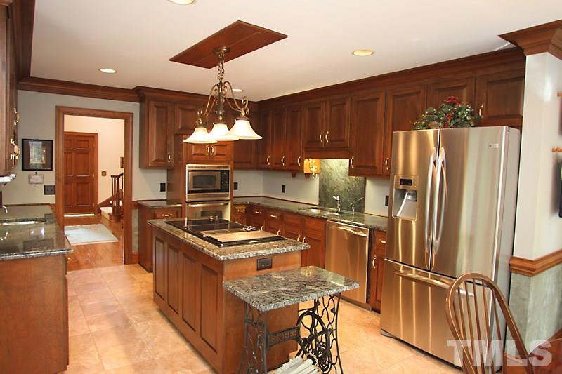 12332 Galway Drive Raleigh, NC 27613 - Photo 8 of 25 Kitchen features updated lighting, granite countertops, wet bar / vegetable sink area, center cooktop island, stainless appliances, and more. Notice the countertop space and cabinet storage.