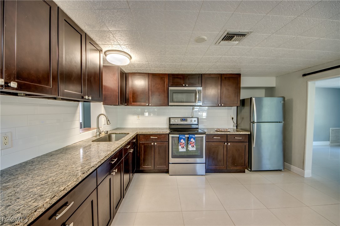 19330 Meredith Road North Fort Myers, FL 33917 - Photo 15 of 50 a large kitchen with granite countertop stainless steel appliances and a sink