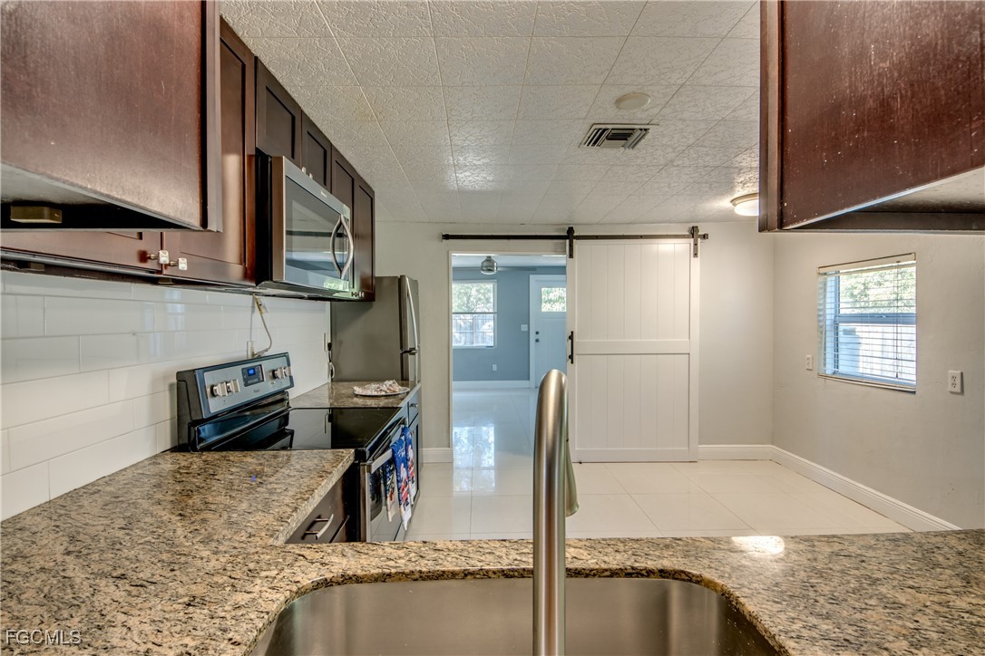 19330 Meredith Road North Fort Myers, FL 33917 - Photo 17 of 50 a kitchen with a refrigerator a sink and a stove top oven