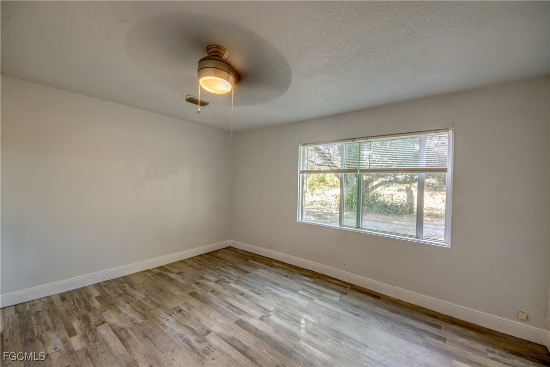 19330 Meredith Road North Fort Myers, FL 33917 - Photo 36 of 50 an empty room with wooden floor and windows