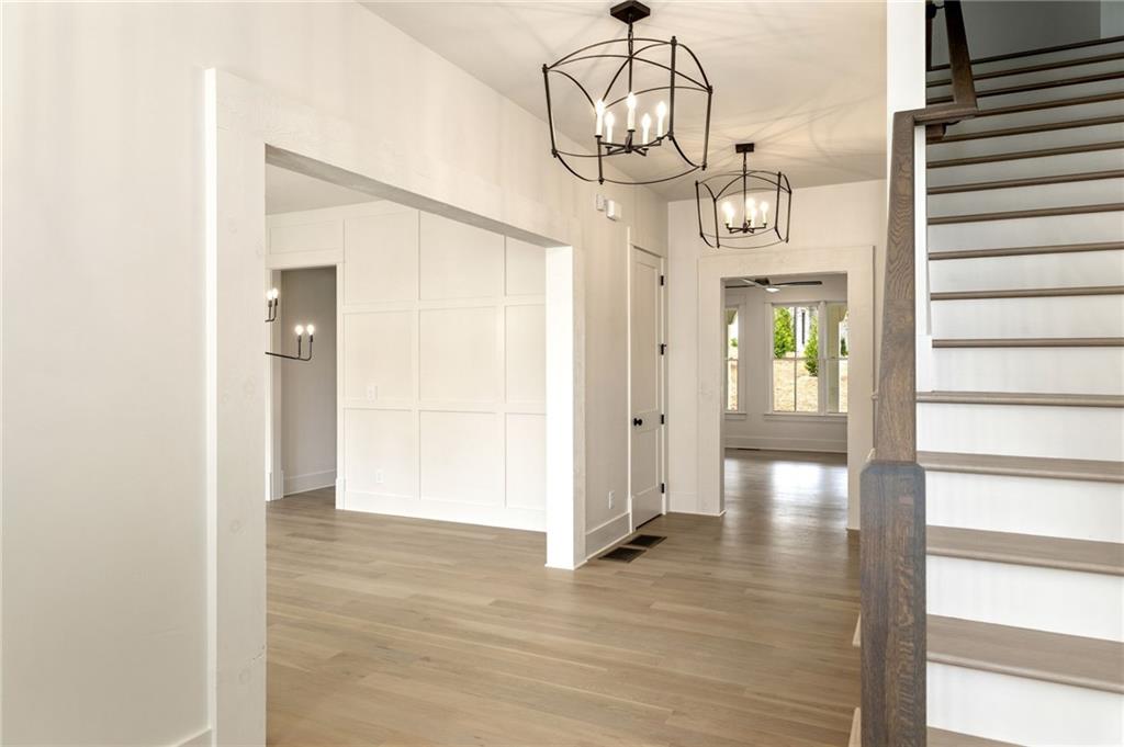 2701 Conns Creek Road, Unit 53 Ball Ground, GA 30107 - Photo 9 of 19 a view of hallway with chandelier and wooden floor