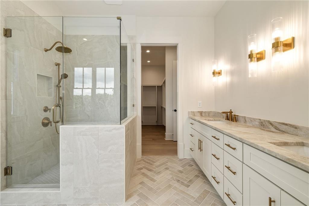 2701 Conns Creek Road, Unit 53 Ball Ground, GA 30107 - Photo 10 of 19 a bathroom with a granite countertop sink a mirror and shower