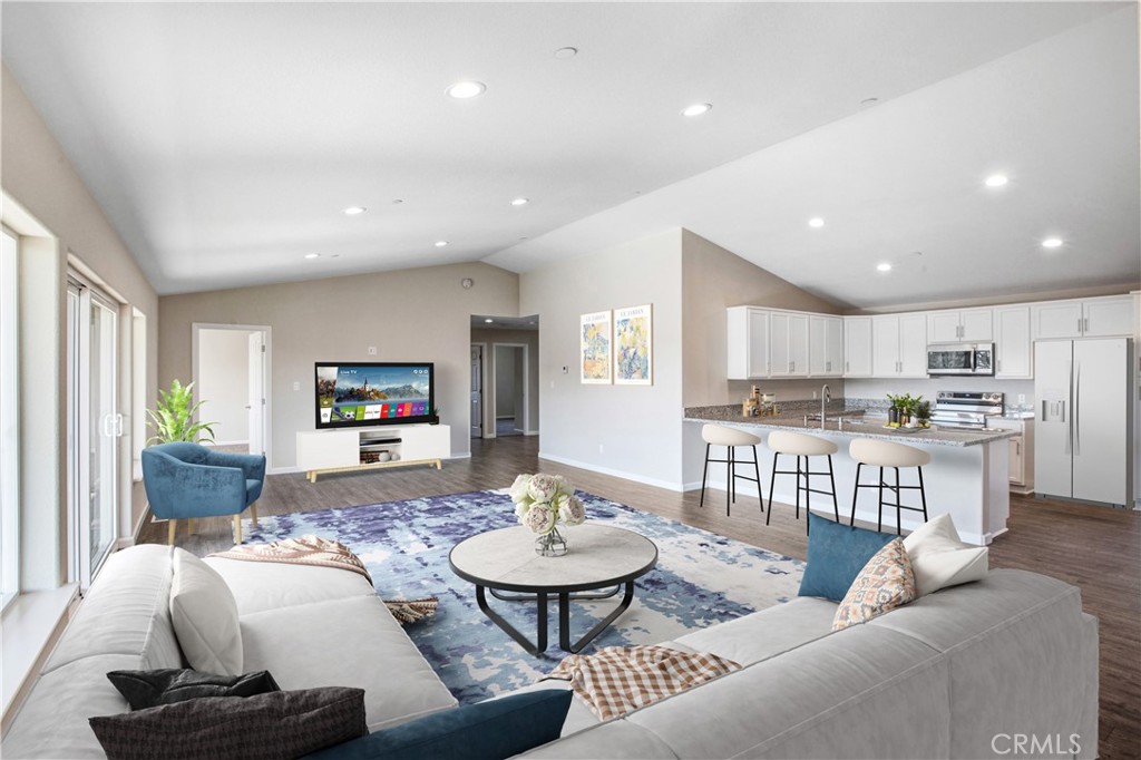 a living room with furniture kitchen view and a large window