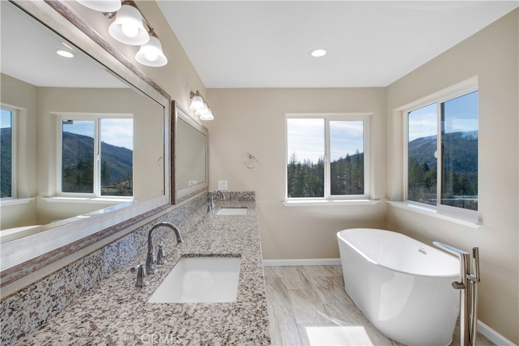 9781 Venturi Drive Cobb, CA 95426 - Photo 21 of 26 a bathroom with a granite countertop sink mirror and a large window
