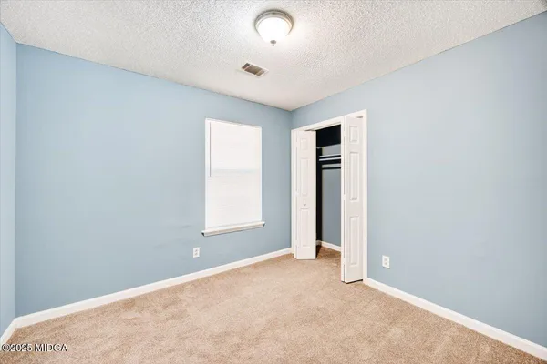 an empty room with windows and closet