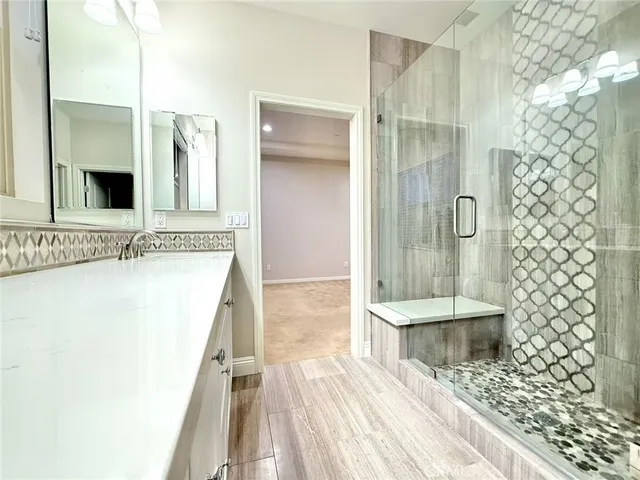 a spacious bathroom with a granite countertop shower a sink and a mirror