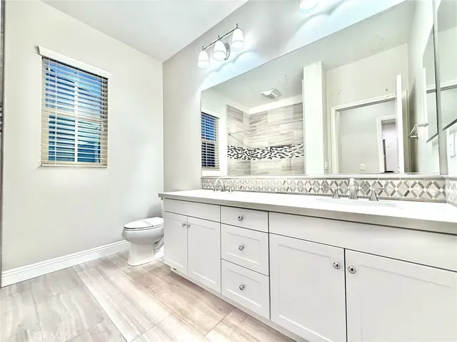 a bathroom with a sink a toilet and a mirror