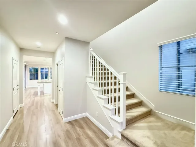 a view of a hallway with wooden floor and entryway