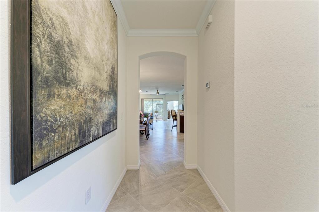 12440 Amica Loop Venice, FL 34293 - Photo 18 of 87 a view of a hallway view with large window and wooden floor