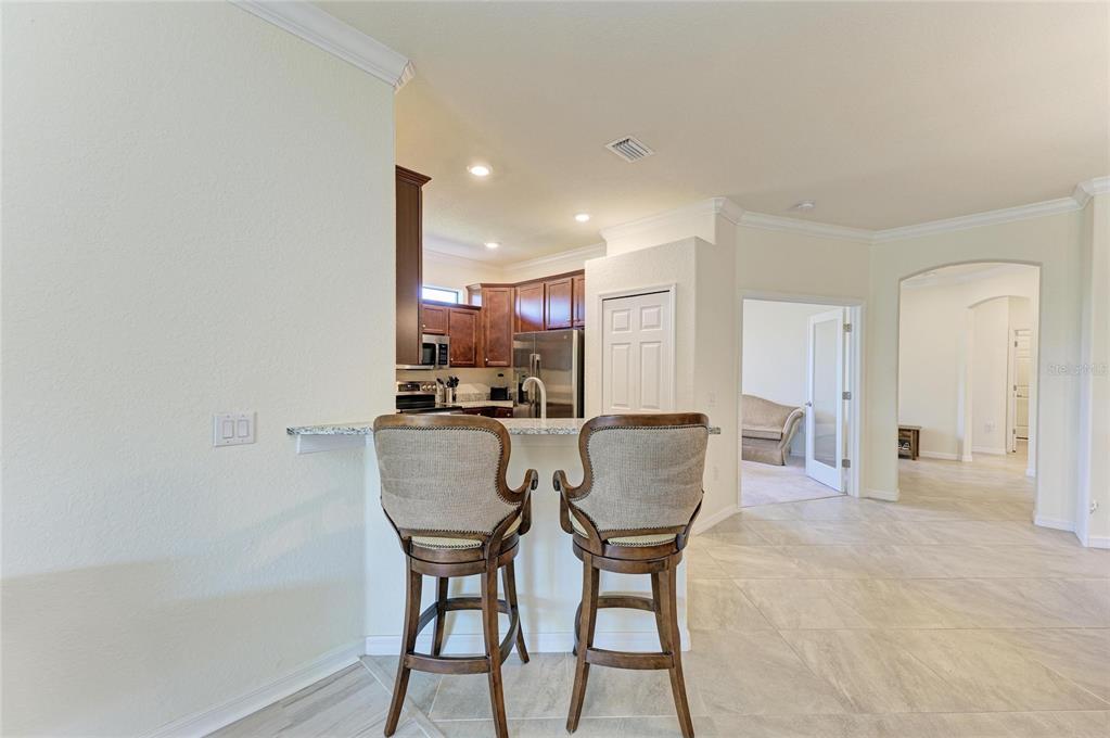 12440 Amica Loop Venice, FL 34293 - Photo 23 of 87 a view of a dining room with furniture and wooden floor