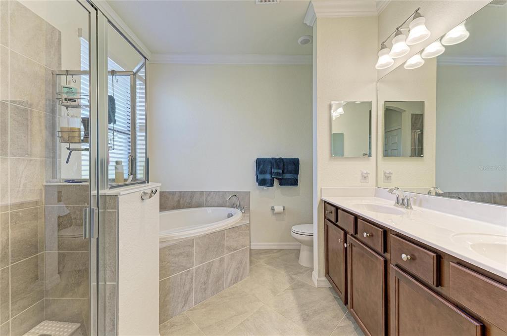 12440 Amica Loop Venice, FL 34293 - Photo 44 of 87 a spacious bathroom with a granite countertop sink a toilet a mirror and shower