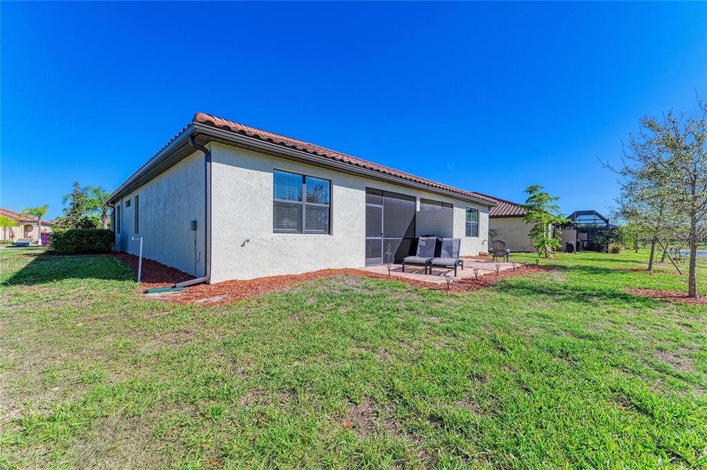 12440 Amica Loop Venice, FL 34293 - Photo 56 of 87 a front view of house with yard and outdoor seating