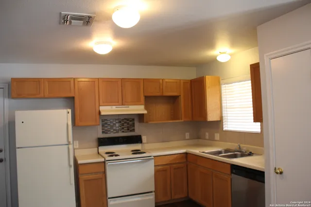 a kitchen with a sink a refrigerator and cabinets