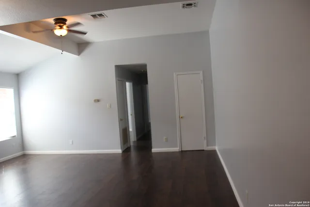 a view of an empty room with wooden floor
