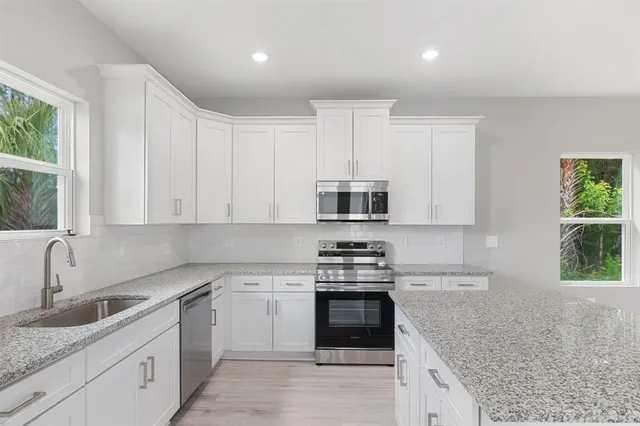 a kitchen with stainless steel appliances granite countertop a sink stove and refrigerator