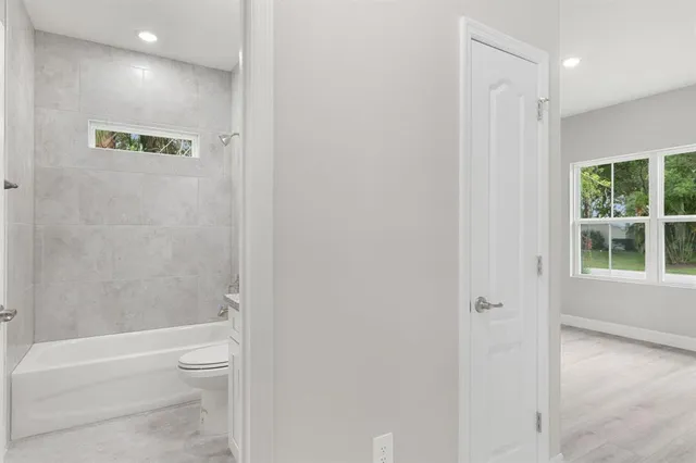 a bathroom with a granite countertop sink toilet and bathtub