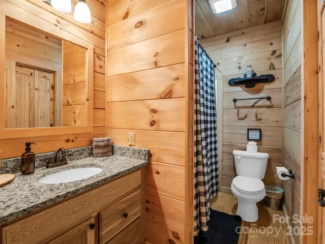 a bathroom with a granite countertop toilet sink and mirror