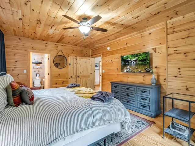 a bedroom with a bed and a flat tv screen