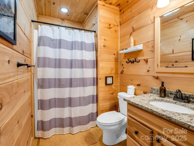 a bathroom with a granite countertop toilet a sink and a mirror