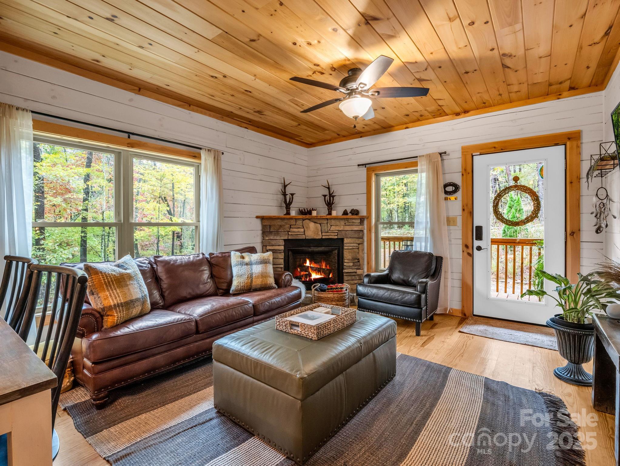 174 Doves Way Lake Lure, NC 28746 - Photo 2 of 42 a living room with furniture a fireplace and a large window