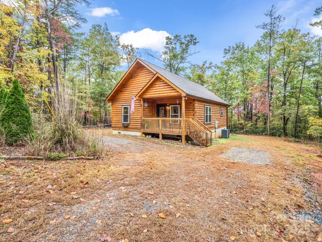 a view of a house with a yard covered in the forest