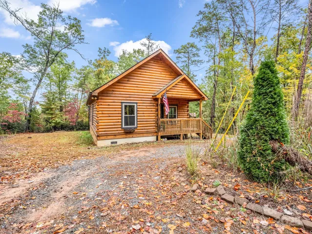 a view of a house with backyard and trees
