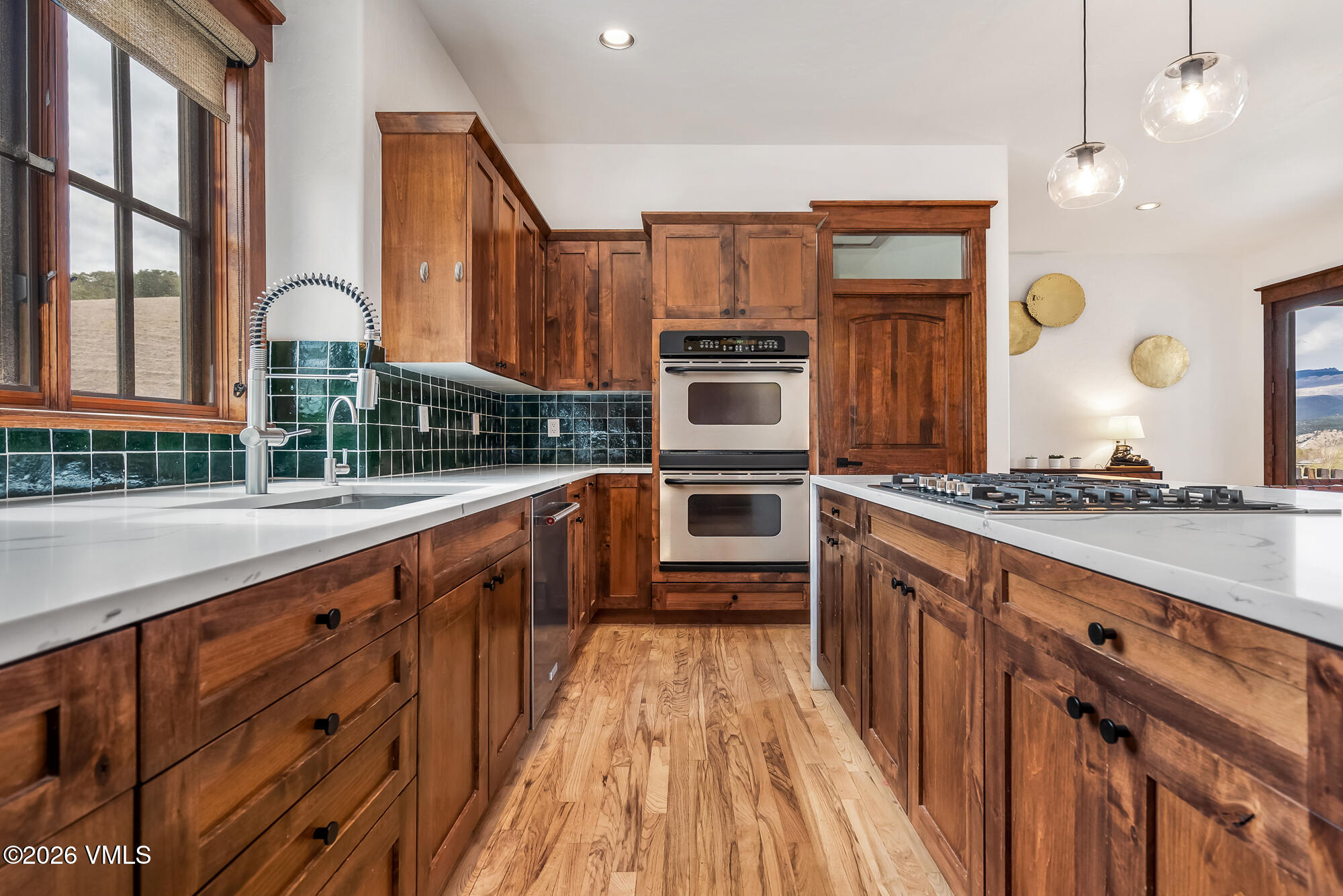 32 Newquist Street Eagle, CO 81631 - Photo 9 of 57 a large kitchen with stainless steel appliances a large counter top a stove and a wooden floors