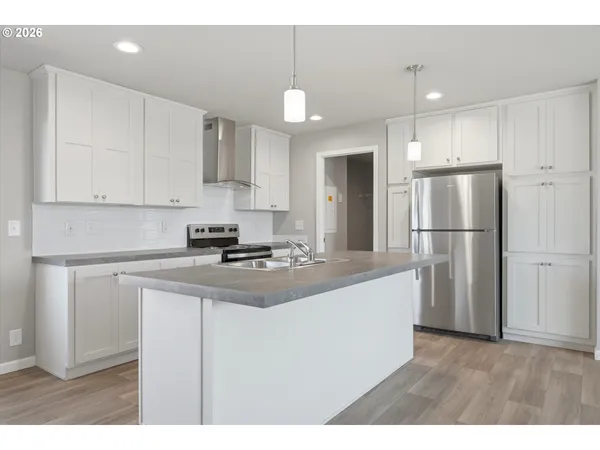 a kitchen with a stove a sink a refrigerator and window