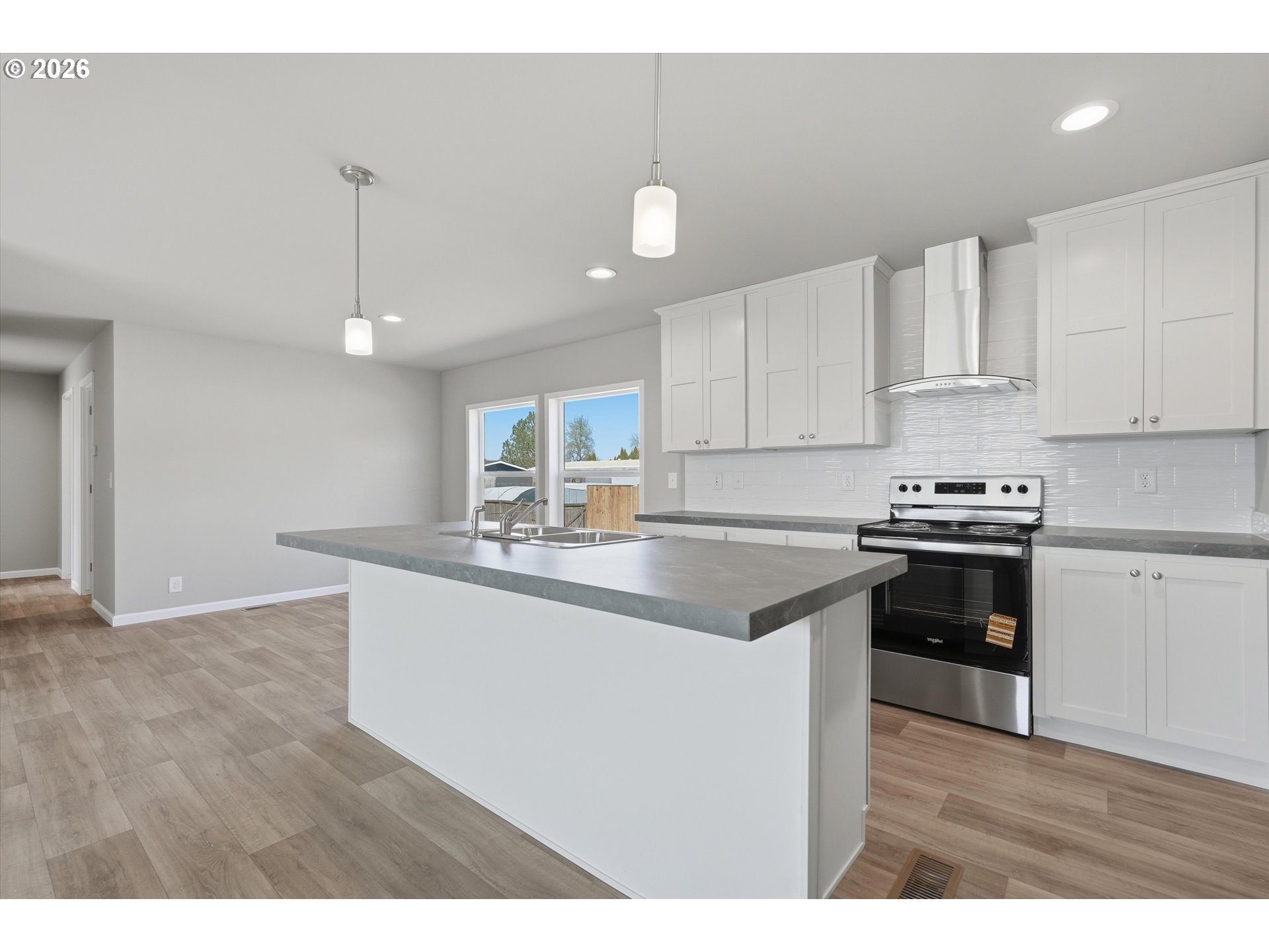 412 Rosedell Street Amity, OR 97101 - Photo 17 of 38 a kitchen with stainless steel appliances granite countertop a sink stove and white cabinets with wooden floor